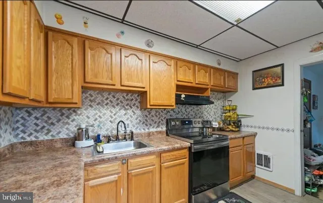 a kitchen with stainless steel appliances granite countertop a sink stove and cabinets