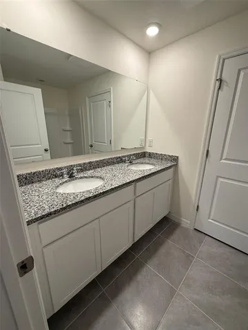 a bathroom with a granite countertop sink and a mirror