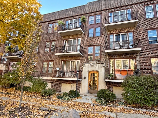a front view of a residential apartment building with a yard and balcony