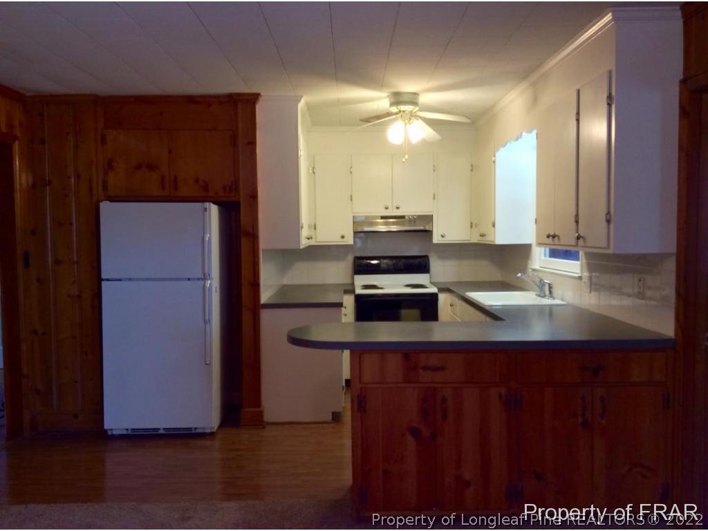 298 Magnolia Church Road Stedman, NC 28391 - Photo 22 of 33 a kitchen with kitchen island a sink stainless steel appliances and cabinets