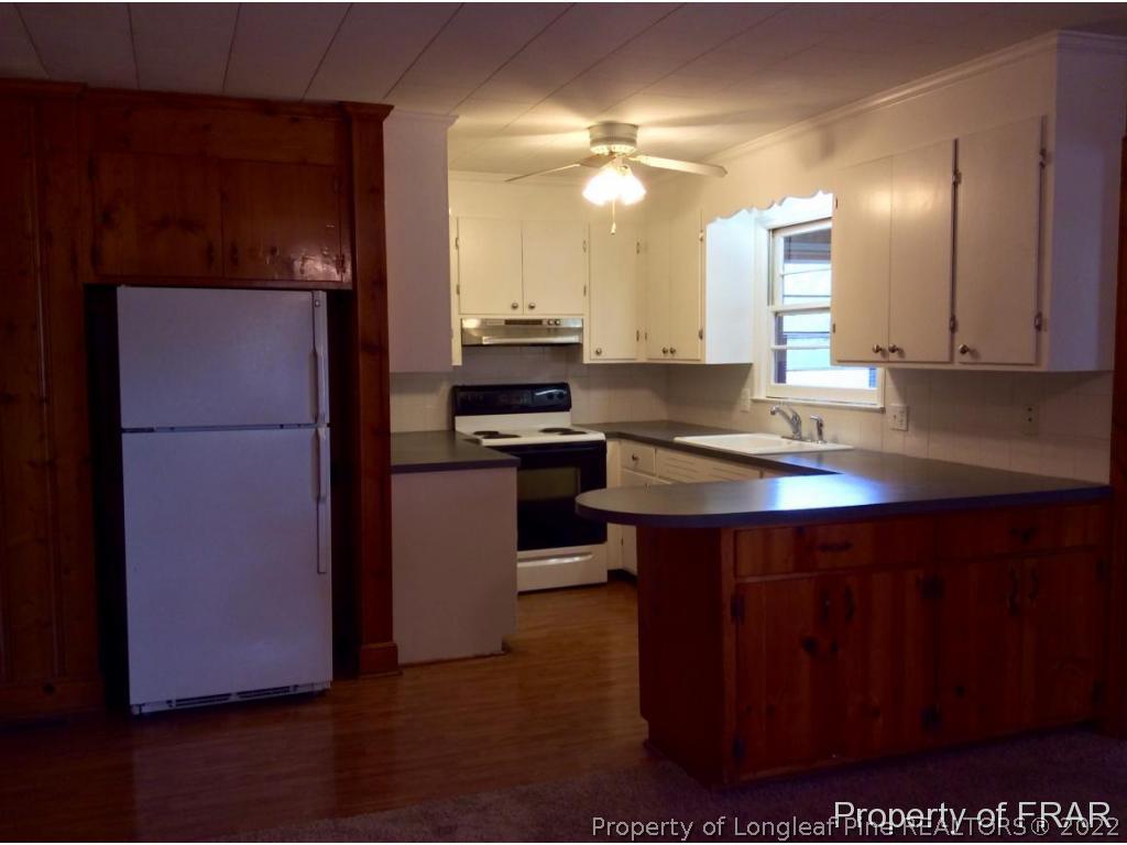298 Magnolia Church Road Stedman, NC 28391 - Photo 23 of 33 a kitchen with kitchen island a counter top space cabinets and stainless steel appliances