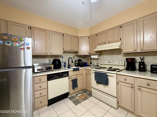 a kitchen with white cabinets stainless steel appliances and sink