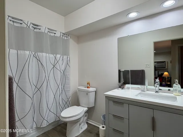a bathroom with a granite countertop sink toilet and a mirror