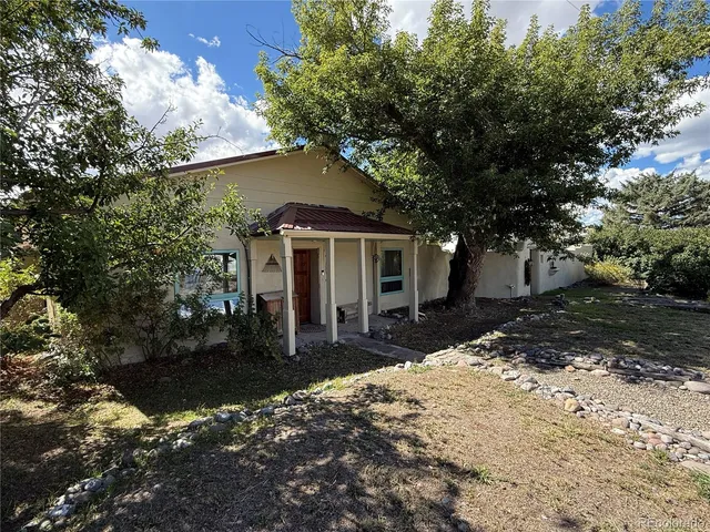 a front view of a house with a yard and trees