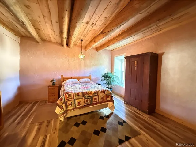 a bed sitting in a spacious bedroom next to a window