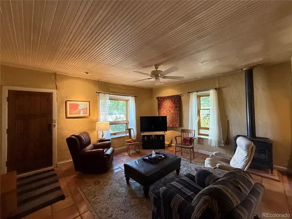 a living room with furniture ceiling fan and a window