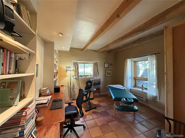 a view of a livingroom with lounge chair and windows