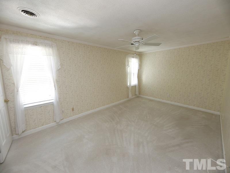 312 Baytree Lane Raleigh, NC 27615 - Photo 8 of 12 an empty room with windows and chandelier fan
