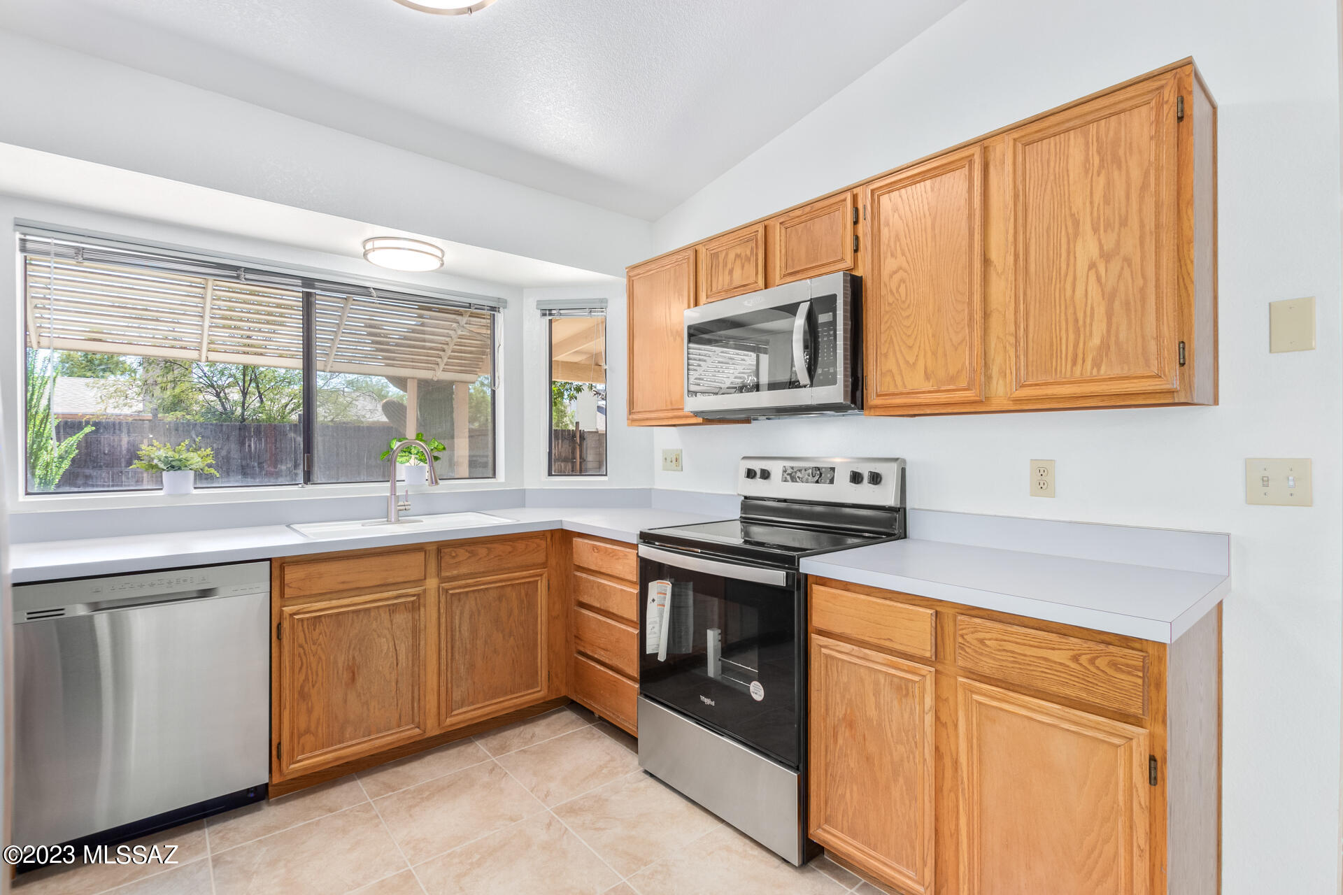 2701 West Firebrook Road Tucson, AZ 85741 - Photo 10 of 28 a kitchen with stainless steel appliances granite countertop wooden cabinets sink and a granite counter top