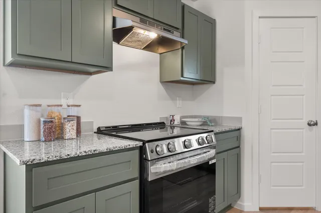 a kitchen with granite countertop cabinets stainless steel appliances and wooden floor