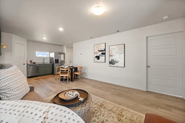 a living room with furniture and a dining table with kitchen view