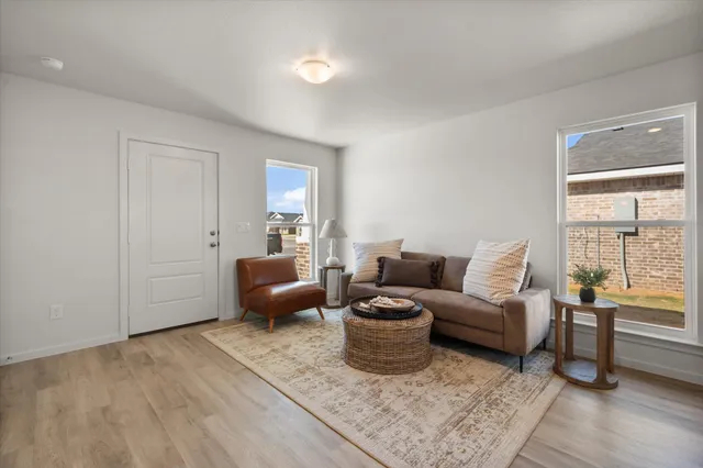 a living room with furniture wooden floor and a window