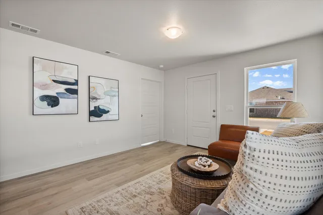 a living room with furniture and a wooden floor
