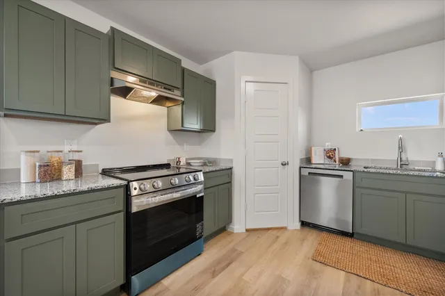 a kitchen with stainless steel appliances granite countertop a stove and a sink
