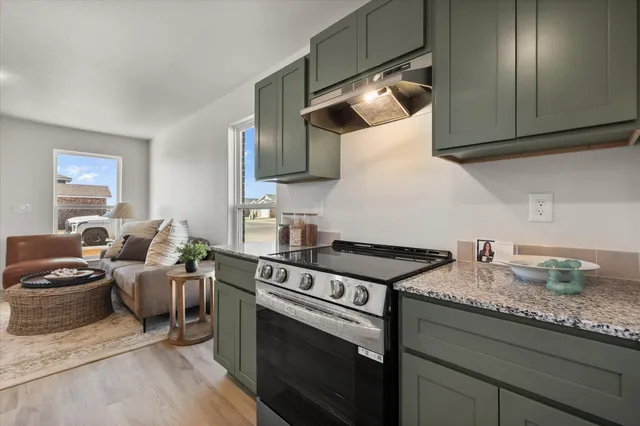 a kitchen with granite countertop a stove and a sink