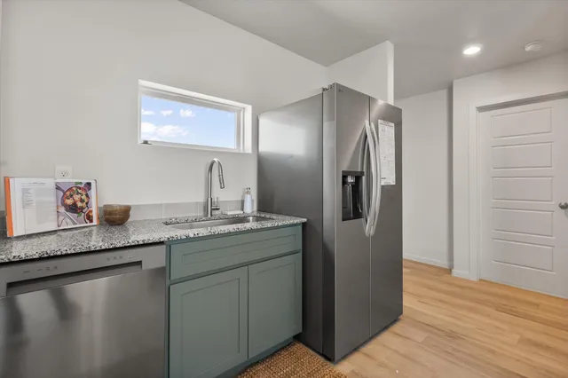 a kitchen with stainless steel appliances granite countertop a refrigerator and a sink