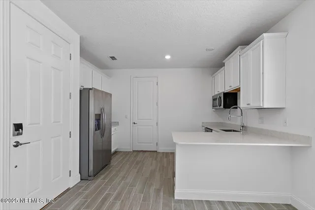 a room with a refrigerator a sink and a mirror