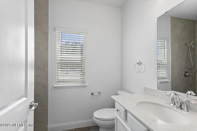 a bathroom with a granite countertop sink toilet a mirror and shower
