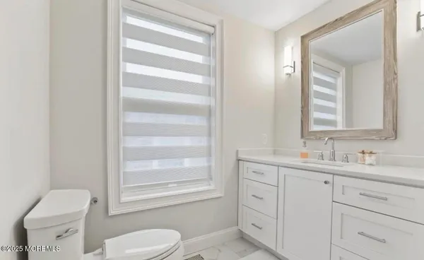 a bathroom with a toilet sink and mirror