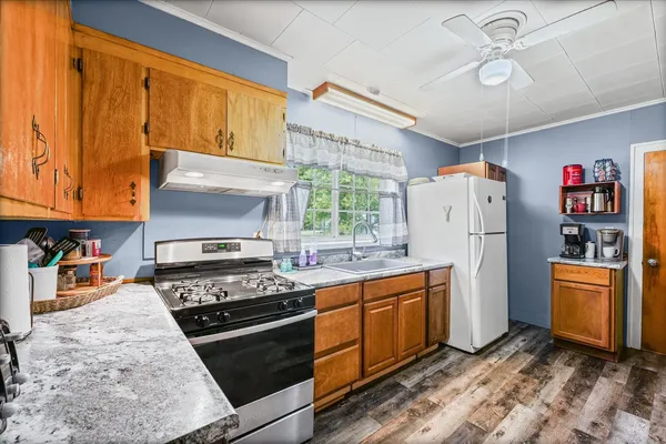 a kitchen with stainless steel appliances granite countertop a refrigerator stove and sink