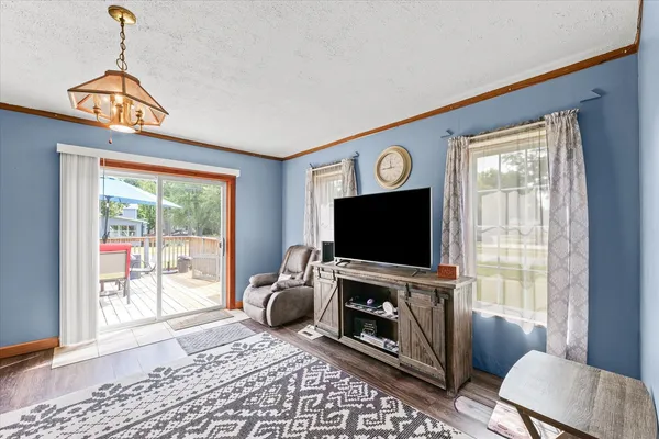 a living room with furniture a flat screen tv and a window