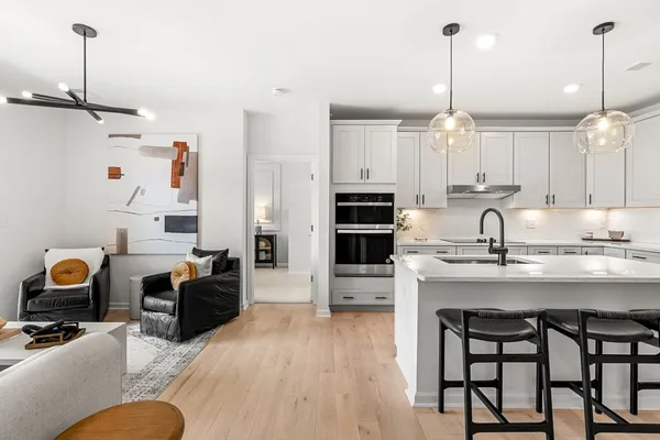 a kitchen with stainless steel appliances granite countertop a stove a sink a refrigerator and wooden floor