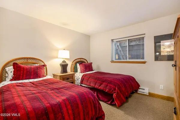 a bedroom with two beds and a window