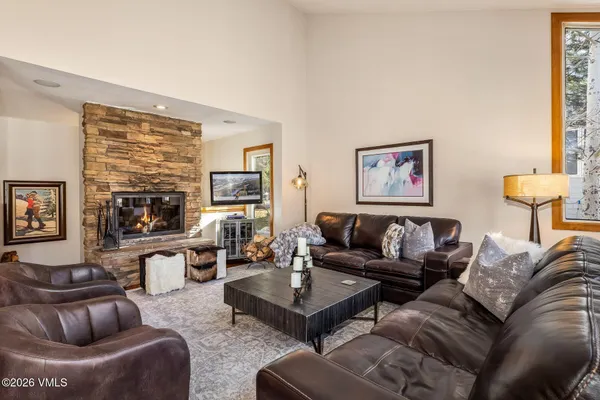 a living room with furniture fireplace and a large window