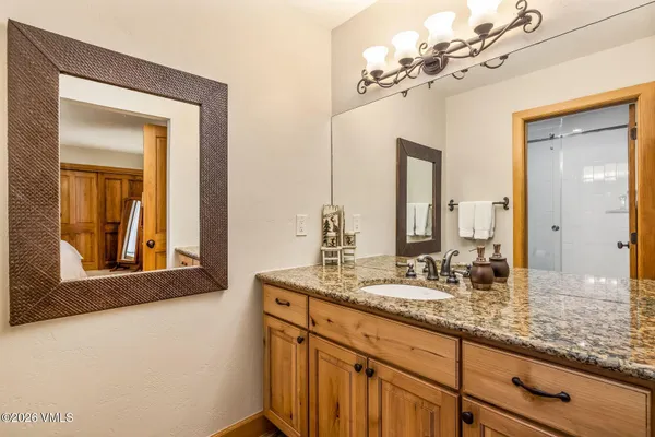 a bathroom with a granite countertop sink and a mirror