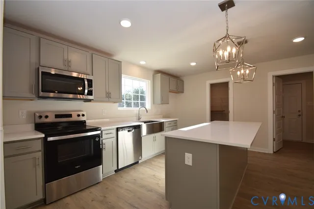 a kitchen with stainless steel appliances a stove sink microwave and refrigerator