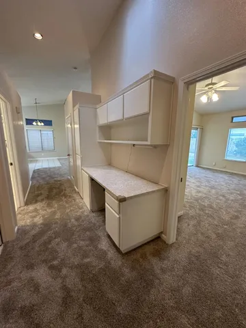 an empty room with windows and fan