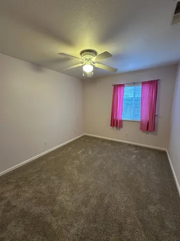 an empty room with a ceiling fan and fan