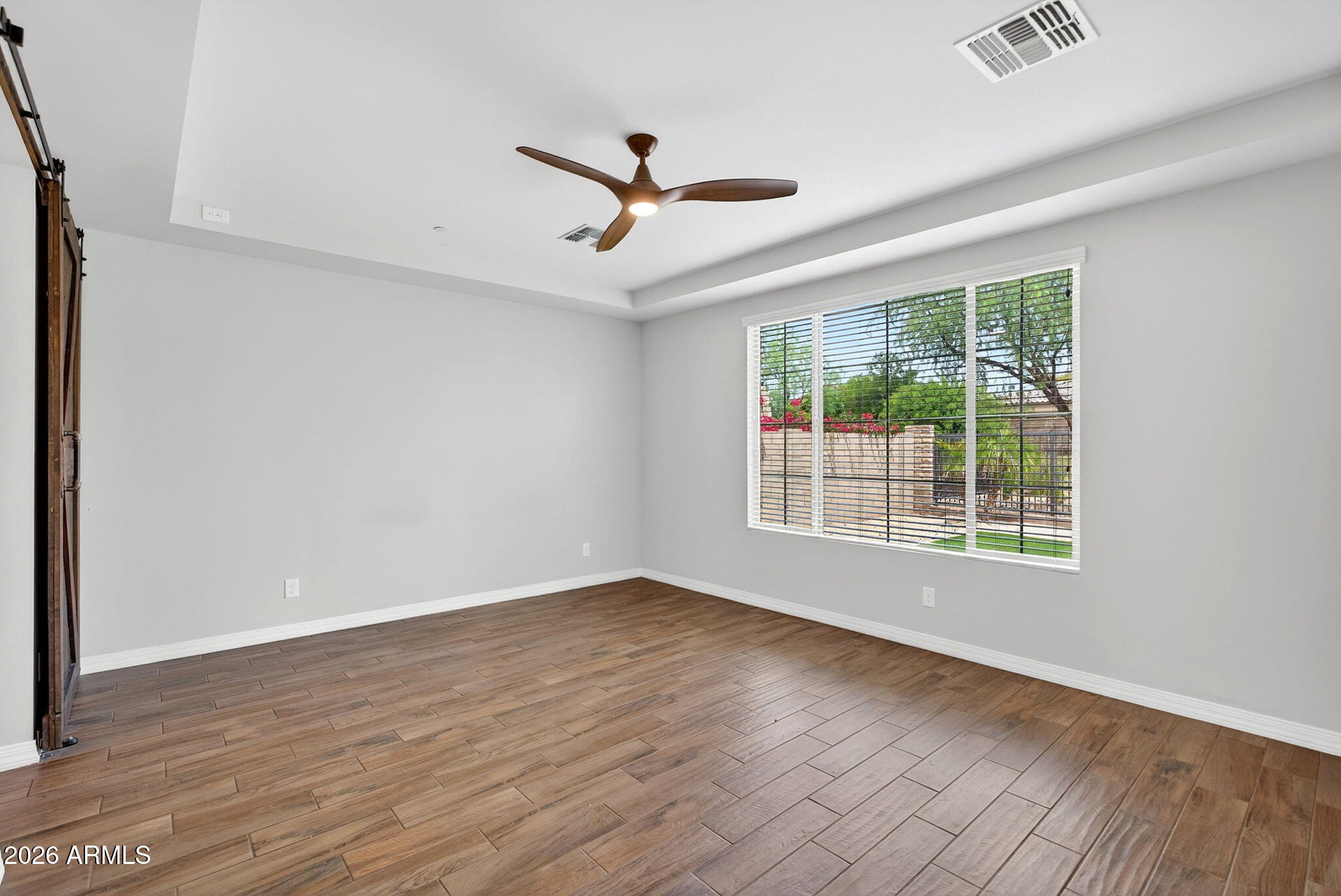 12124 West Peak View Road Peoria, AZ 85383 - Photo 14 of 38 a view of an empty room with wooden floor and a window