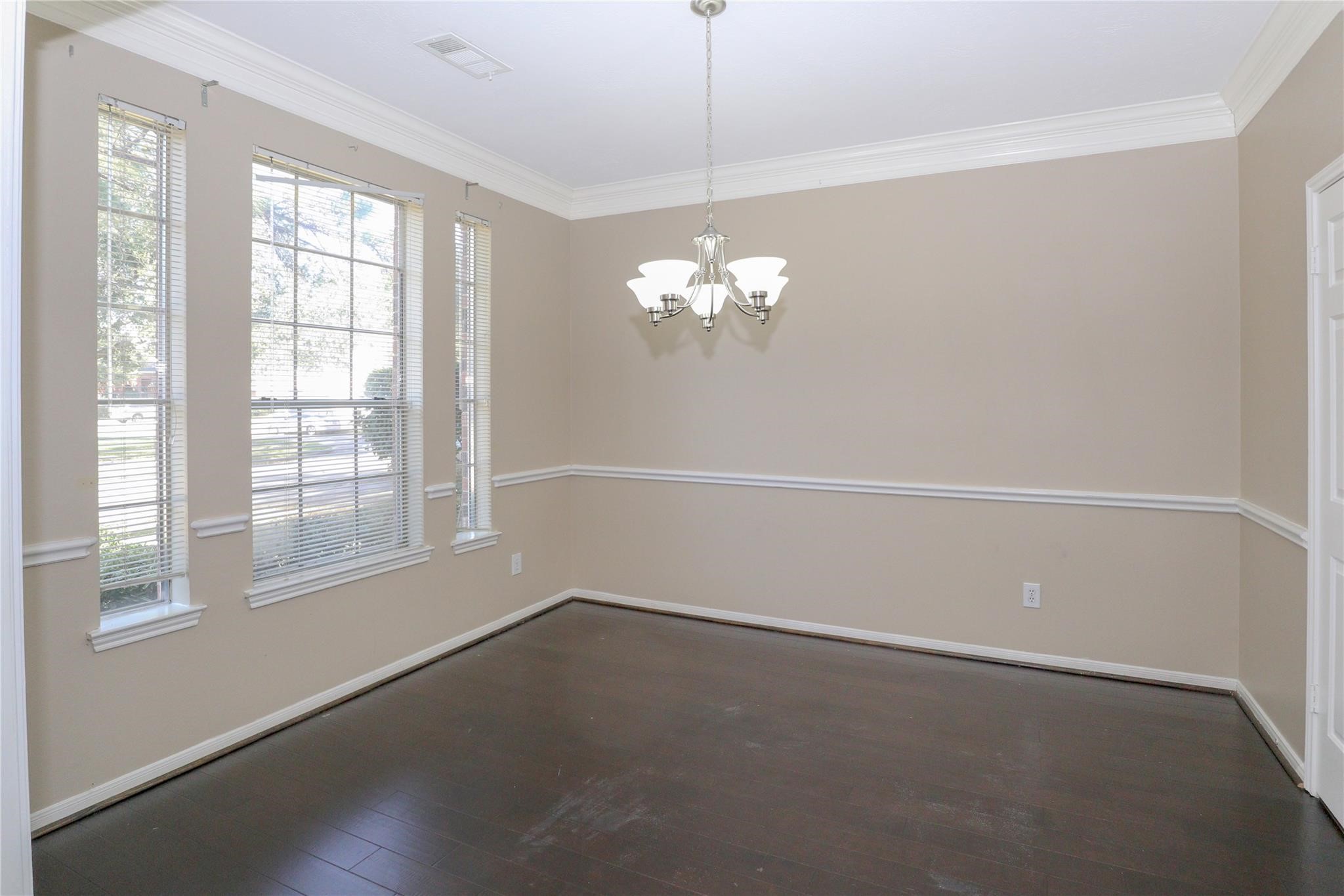 23207 Olive Ridge Court Katy, TX 77494 - Photo 14 of 45 en empty room with windows and chandelier