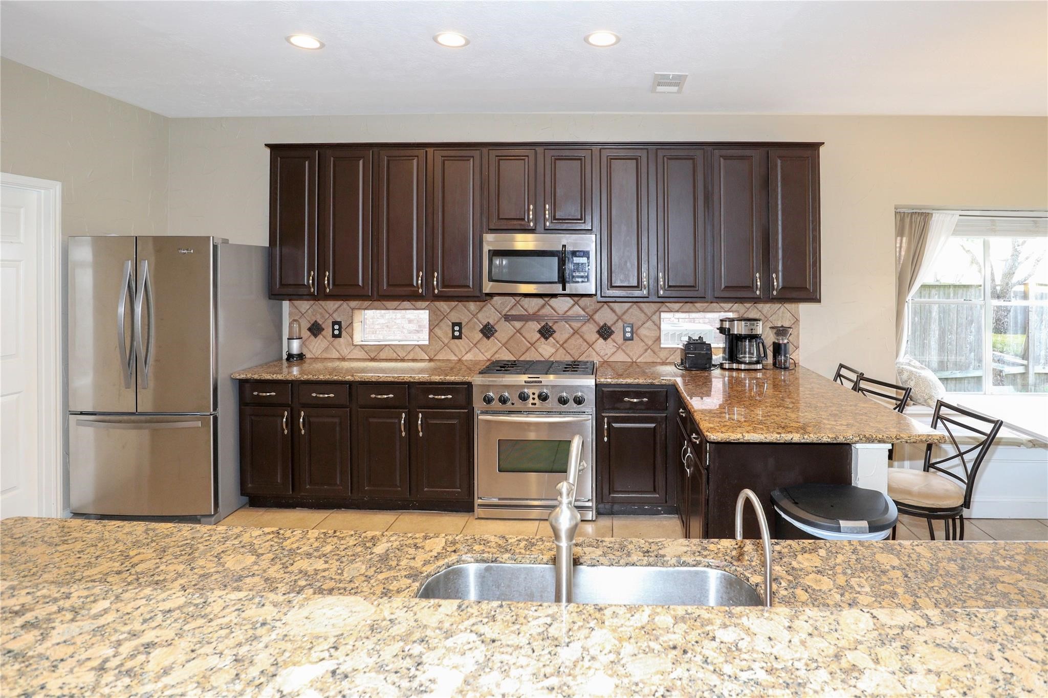 23207 Olive Ridge Court Katy, TX 77494 - Photo 20 of 45 a kitchen with a stove a refrigerator and a sink