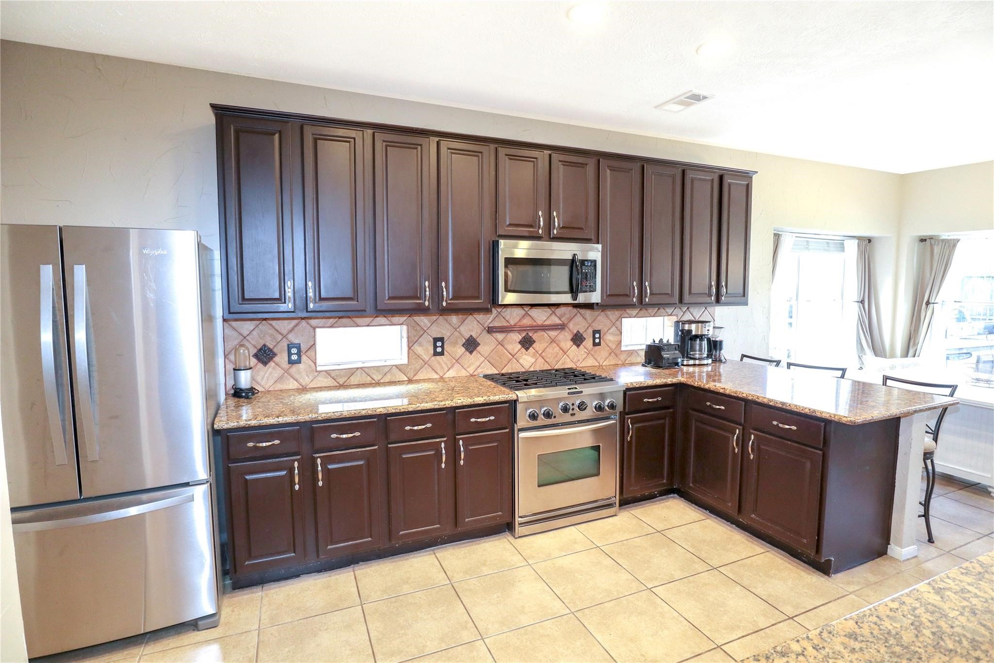 23207 Olive Ridge Court Katy, TX 77494 - Photo 21 of 45 a kitchen with stainless steel appliances granite countertop a stove top oven a sink and a refrigerator