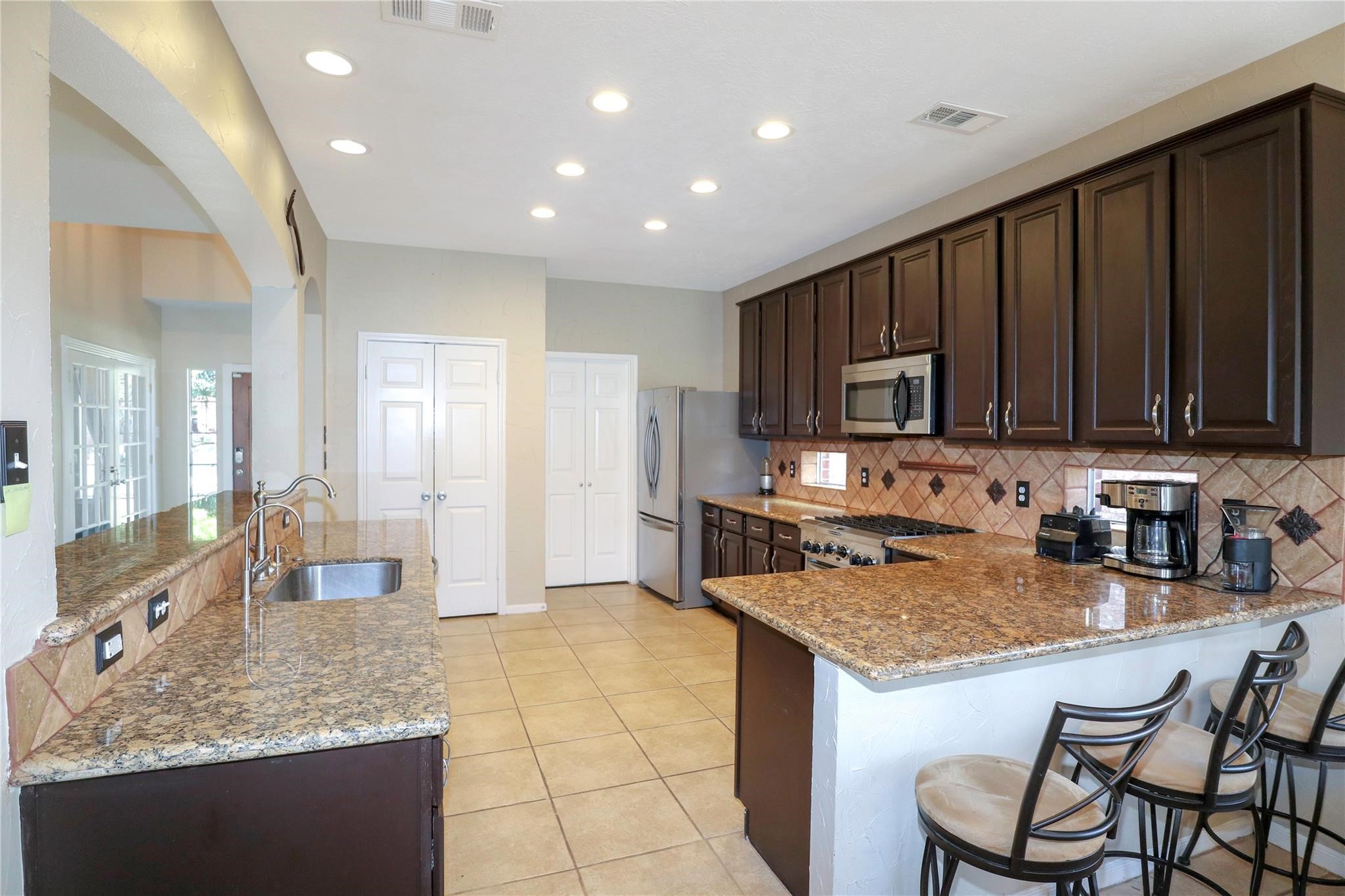 23207 Olive Ridge Court Katy, TX 77494 - Photo 22 of 45 a kitchen with granite countertop sink cabinets and stainless steel appliances