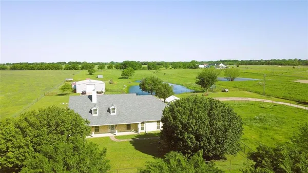 an aerial view of a house with a garden and lake view