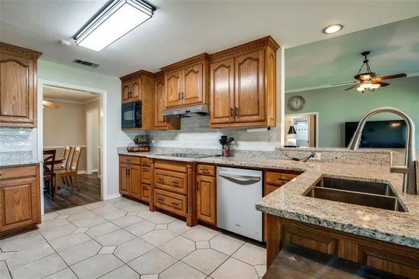 a kitchen with stainless steel appliances granite countertop a sink stove and cabinets