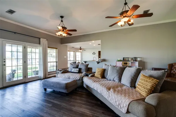 a living room with furniture a ceiling fan and a wooden floor