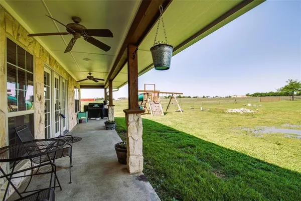 a view of a swimming pool with a lawn chairs and floor to ceiling window