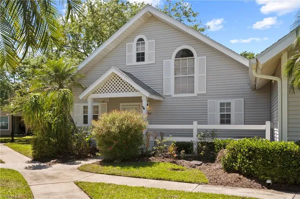 a front view of a house with a yard and potted plants