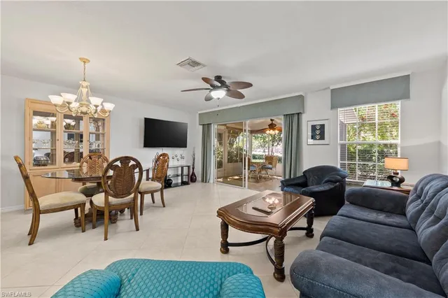 a living room with furniture kitchen view and a chandelier