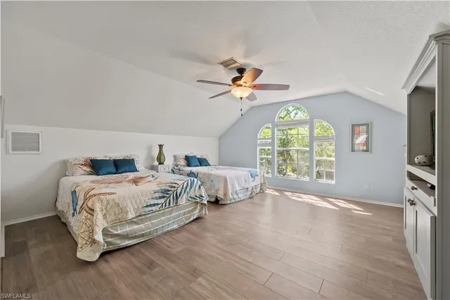 a bedroom with a bed window and a flat screen tv