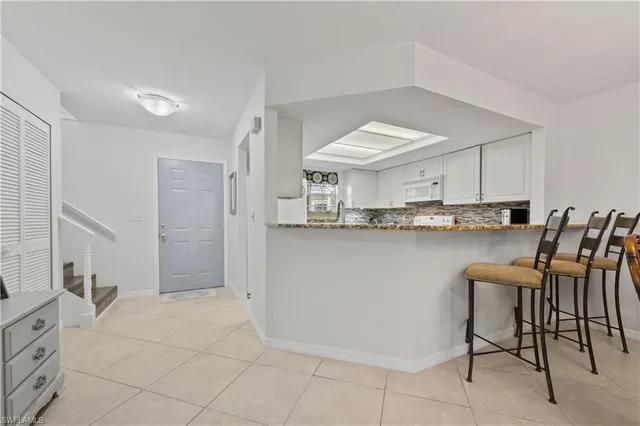 a living room with furniture a chandelier and a flat screen tv