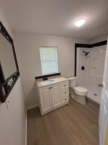 a spacious bathroom with a double vanity sink toilet mirror and shower