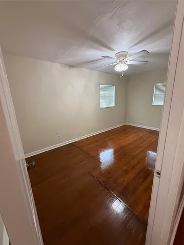 an empty room with a ceiling fan and a window