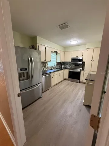 a kitchen with granite countertop a refrigerator and a sink