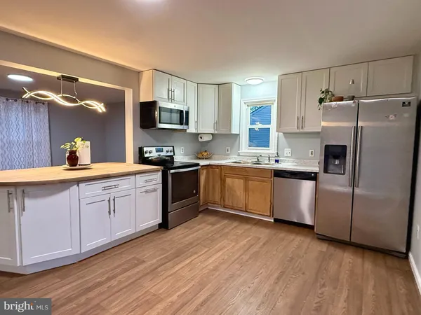 a large kitchen with a white stove top oven and refrigerator