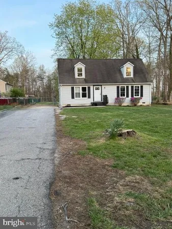 a view of a big yard in front of a house with large trees